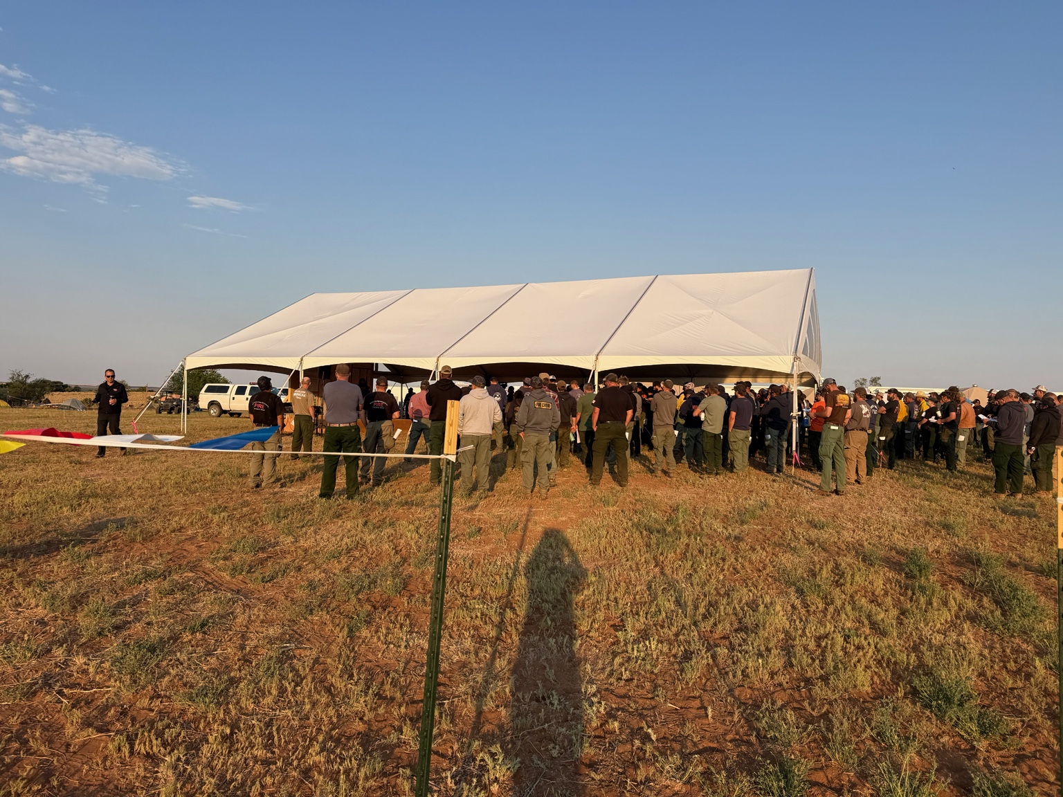 Large canopy sheltering a group during an outdoor field gathering