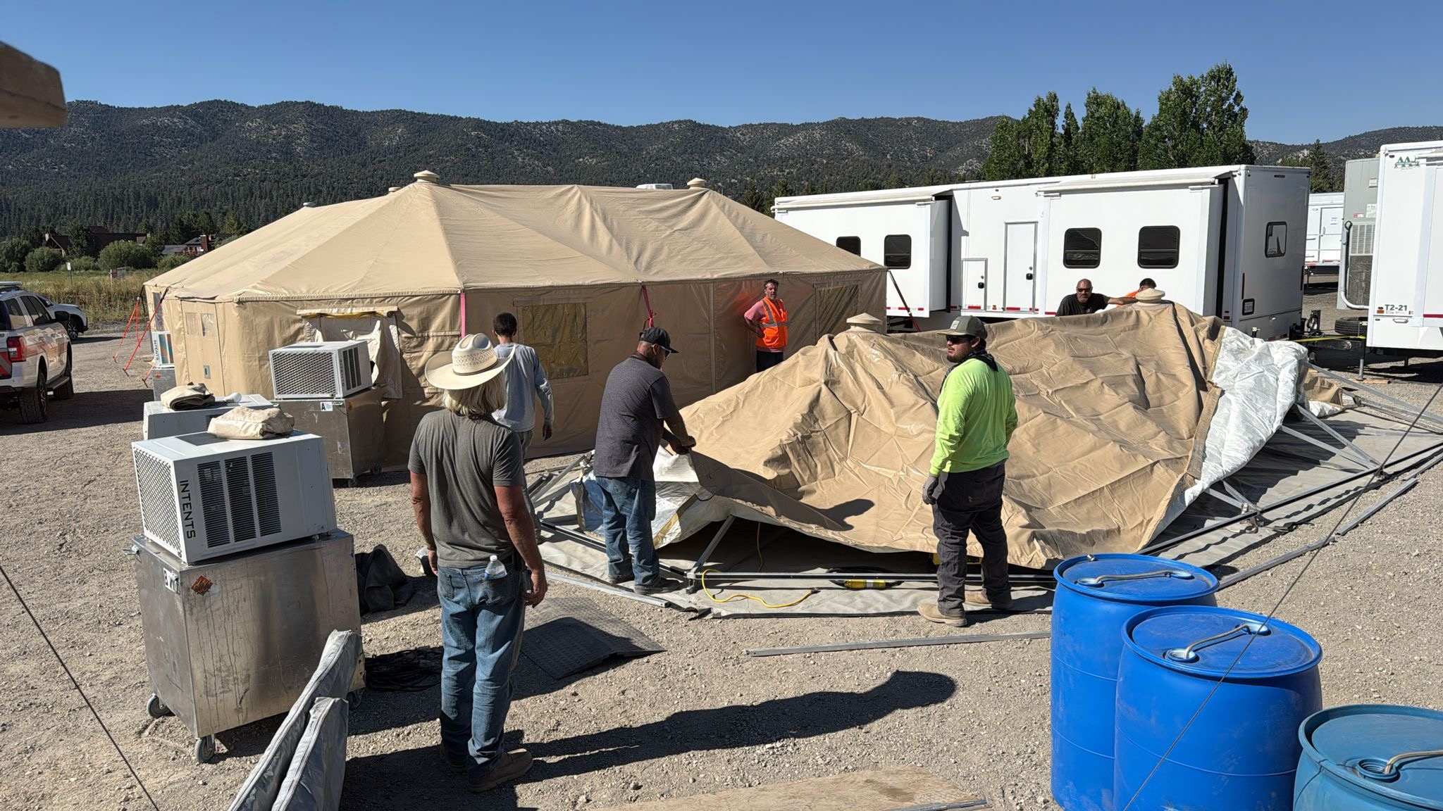 Intents crew setting up a large temporary shelter alongside office trailers and support equipment