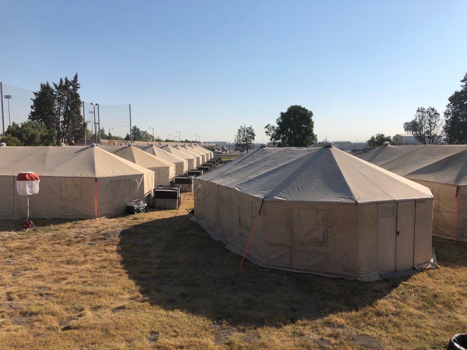 Rows of beige field tents at an operational camp