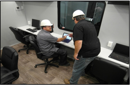 Interior of a mobile office trailer with desks and workstations