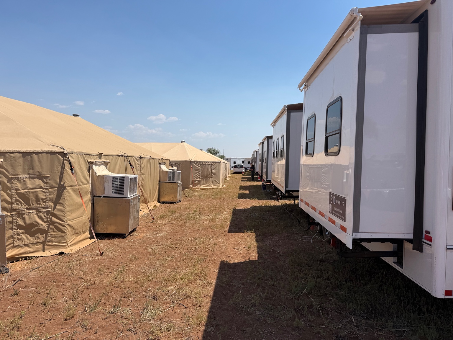 Several office trailers arranged beside field tents